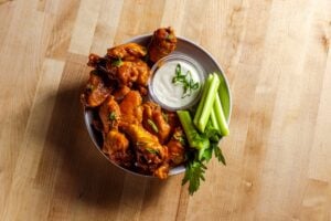 a plate of wings with celery and blue cheese