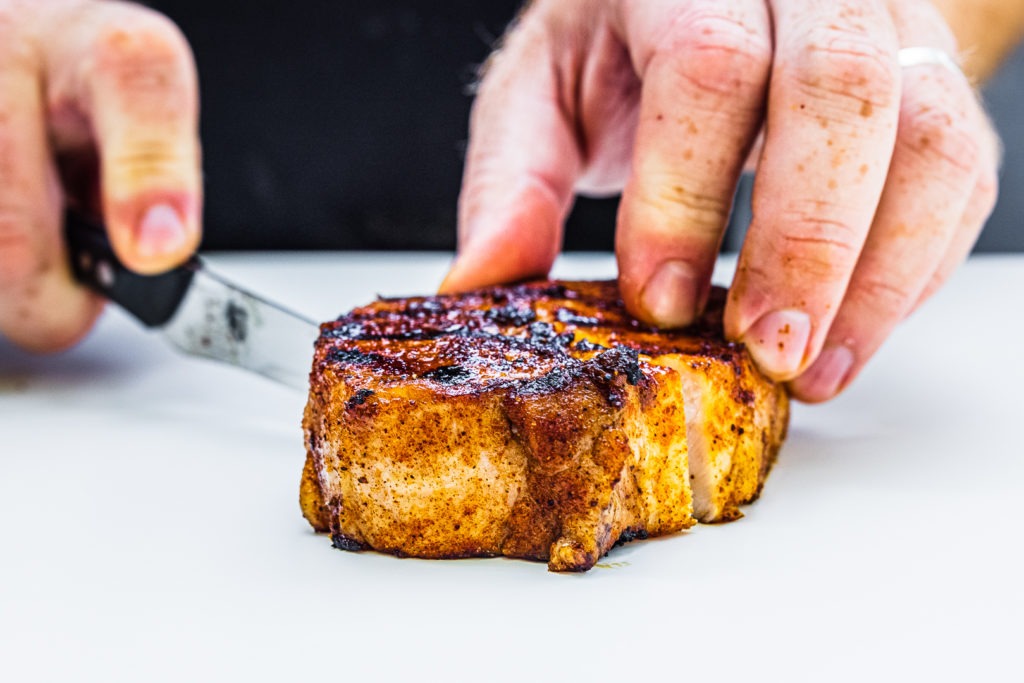 Cutting a grilled pork chop