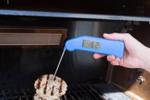 Spot-checking internal temperature of a turkey burger with Classic Thermapen.