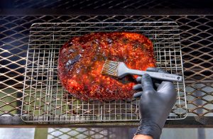 Brushing the meatloaf with sauce