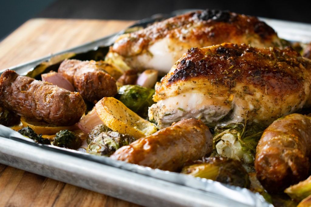 Sheet-pan baked chicken breast recipe with Brussels sprouts and sausages.