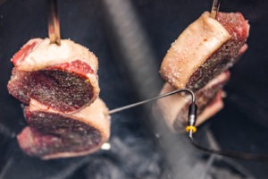 Picanha steaks hanging in a pit barrel