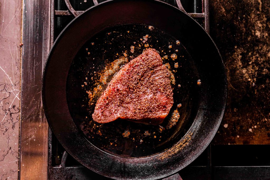 Tuna steak searing in a hot pan
