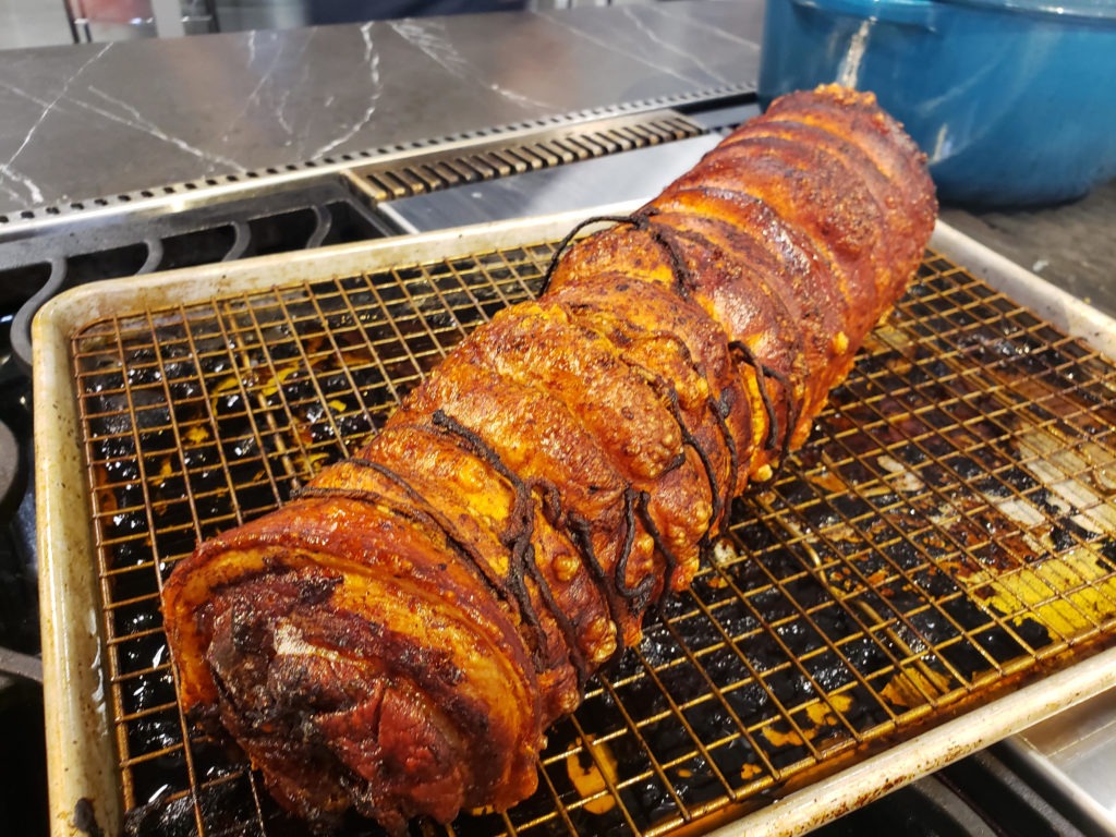 A crisp-skinned porchetta roast resting on the counter. 