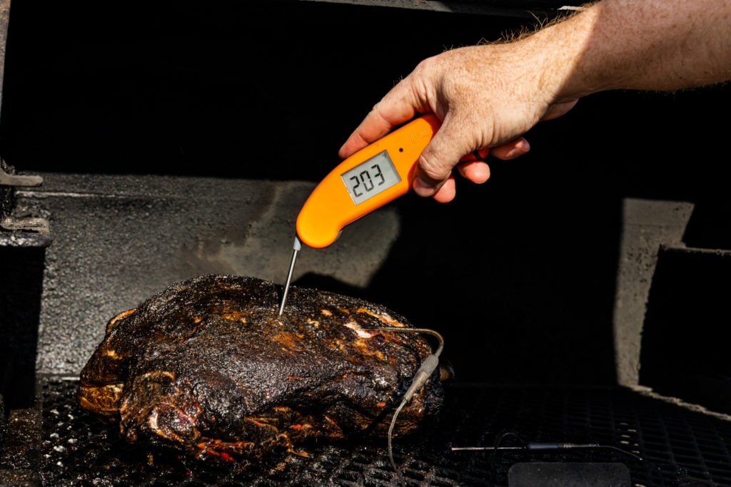 verifying that the temperature of the lamb shoulder is 203°F