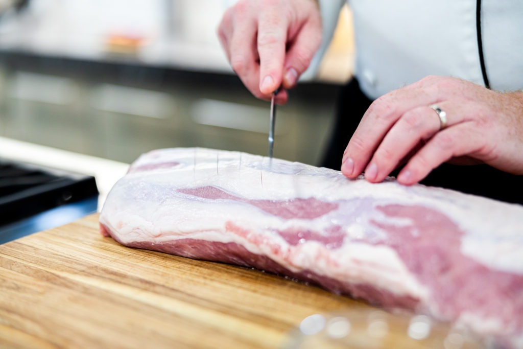 Scoring the fat on the pork loin