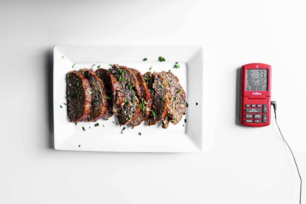 Meatloaf on a plate next to a ChefAlarm thermometer