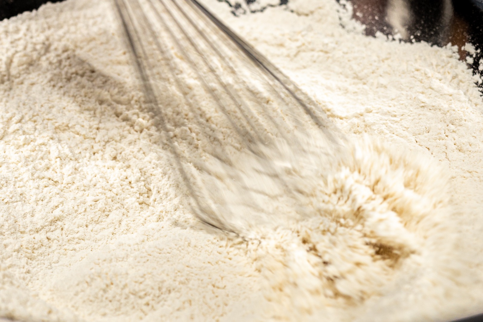 whisking flour with salt for breading