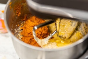 Mixing the eggs and pumpkin into the butter