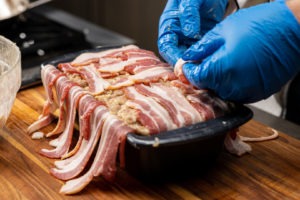 Folding the bacon onto the top of the pâté