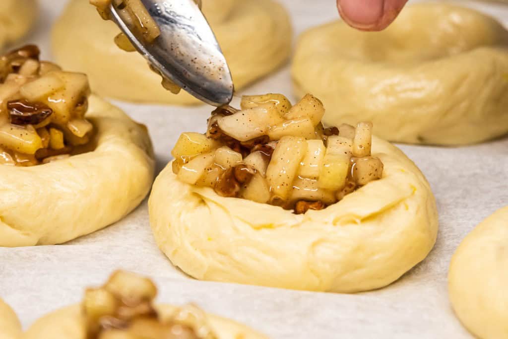 Filling a kolache with apple-pecan filling