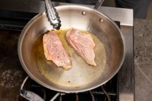 Browning duck breasts in a pan