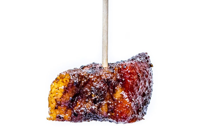 An adobo pork belly burn end on a toothpick