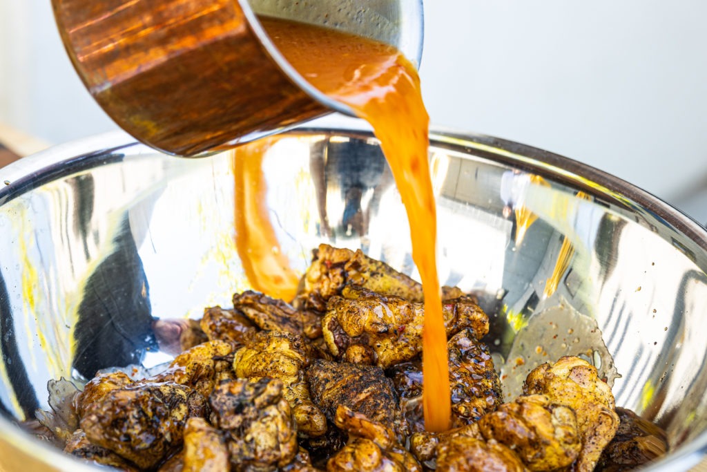 Pouring sauce onto the wings