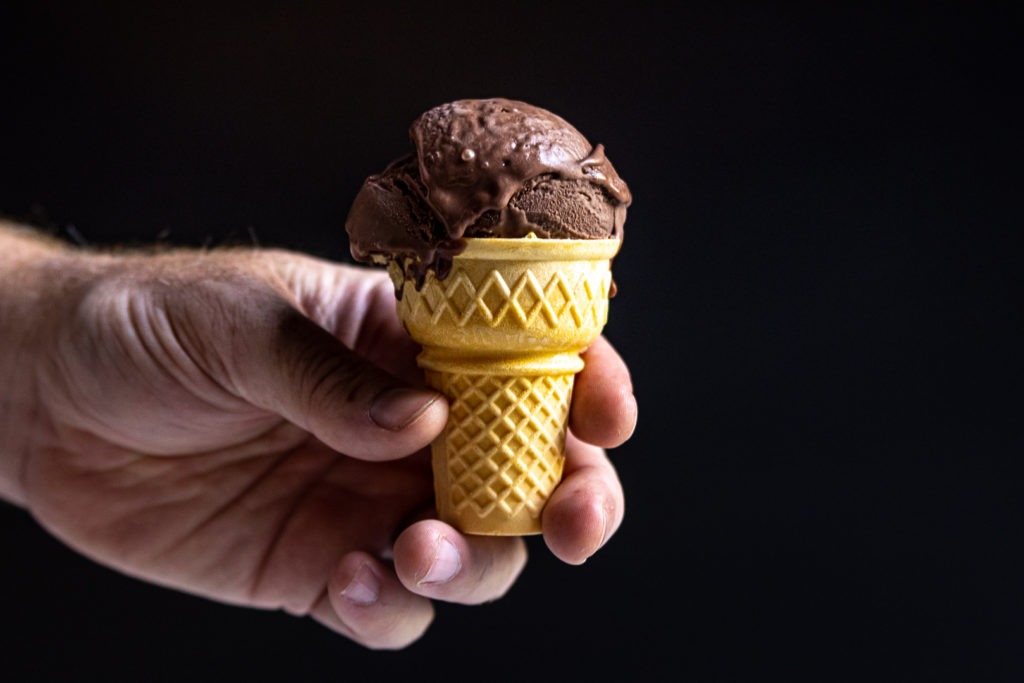 A scoop of homemade ice cream atop a cone