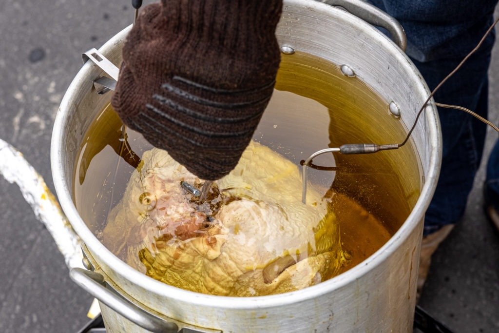 Lowering the turkey into the oil