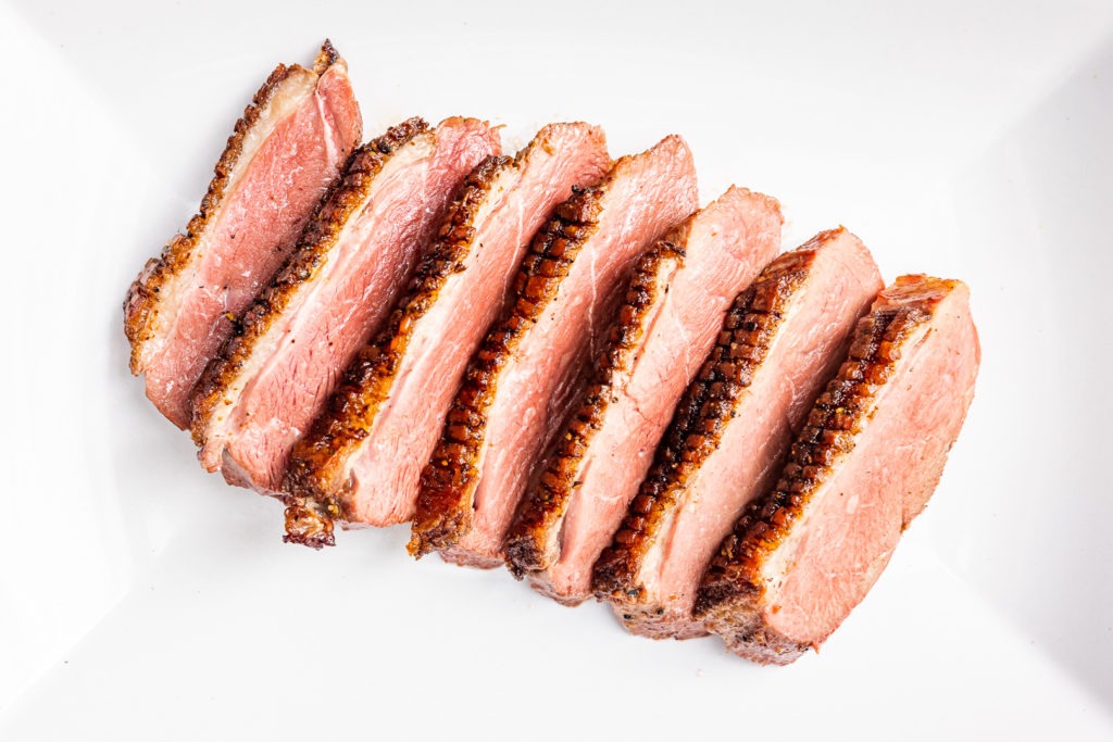 Grilled duck breast, sliced on a platter