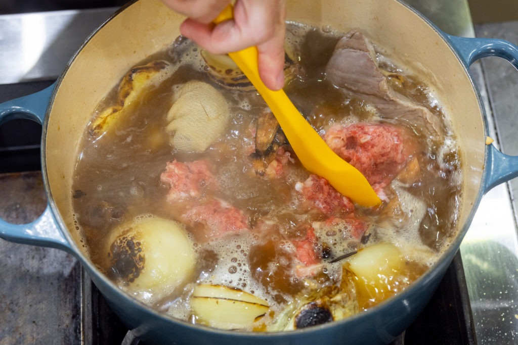 stirring meat into the broth