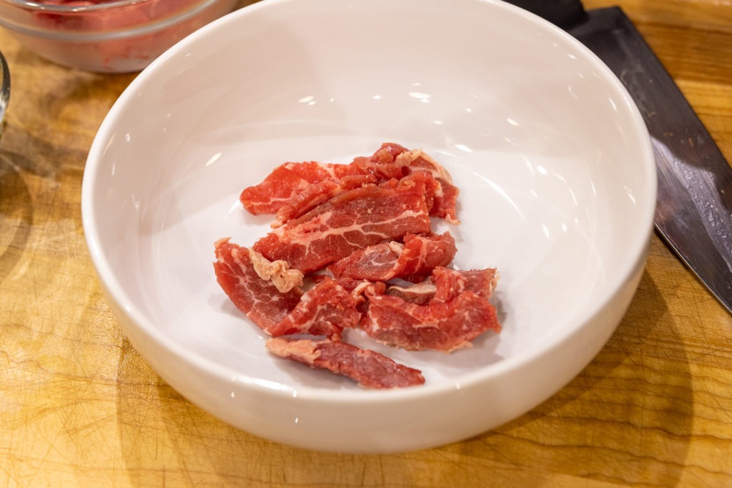 sliced, raw steak in a soup bowl for pho