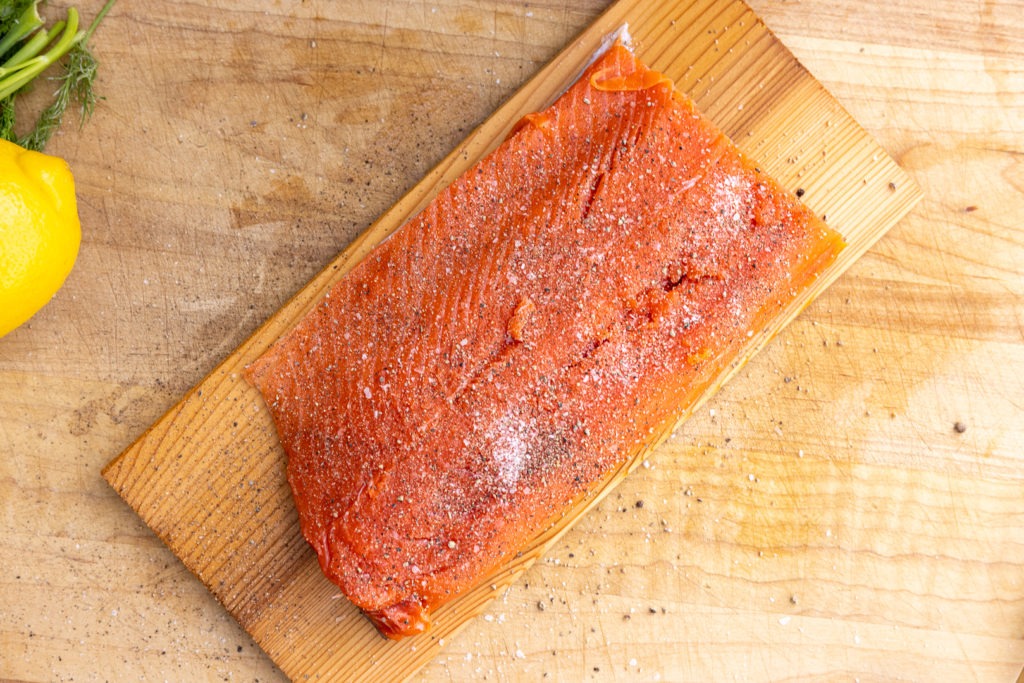 seasoned salmon on a cedar plank ready for grilling