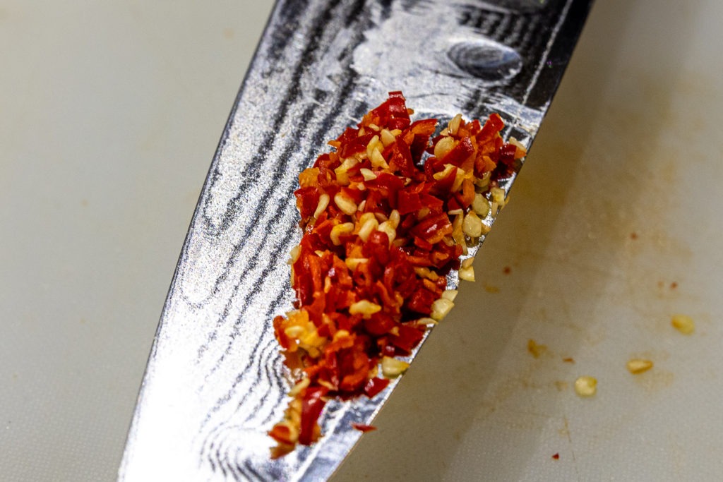 Minced Thai chili on a knife blade