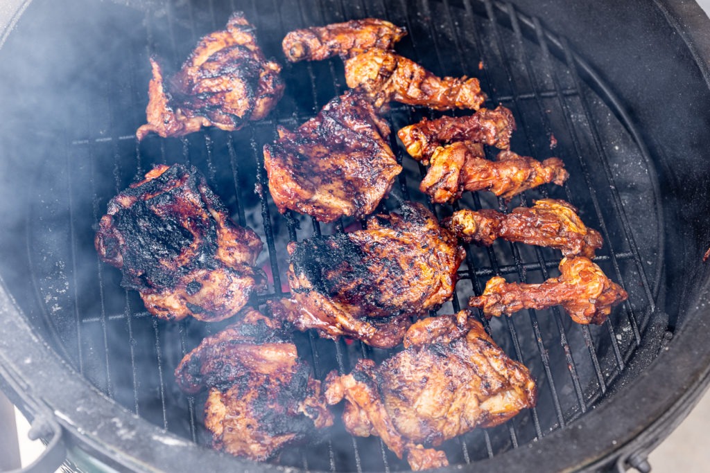 Fire chicken grilling over charcoal. Bones grilling to the right. 