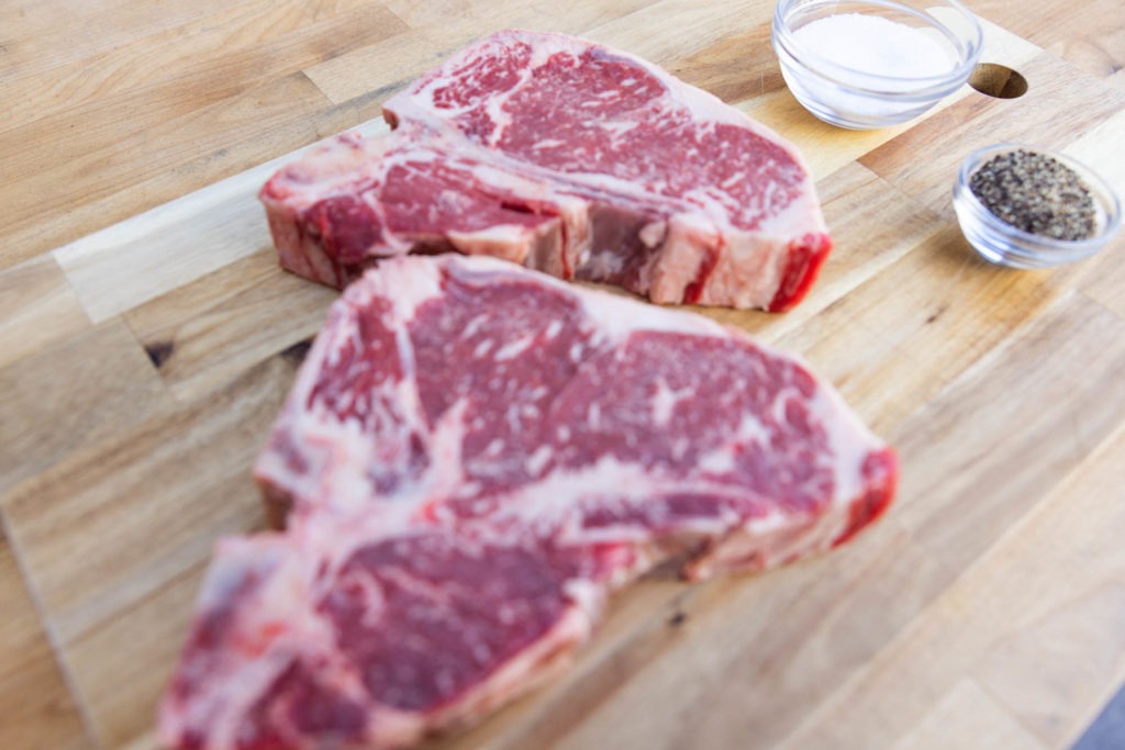 T bone steaks with salt and pepper for grilling