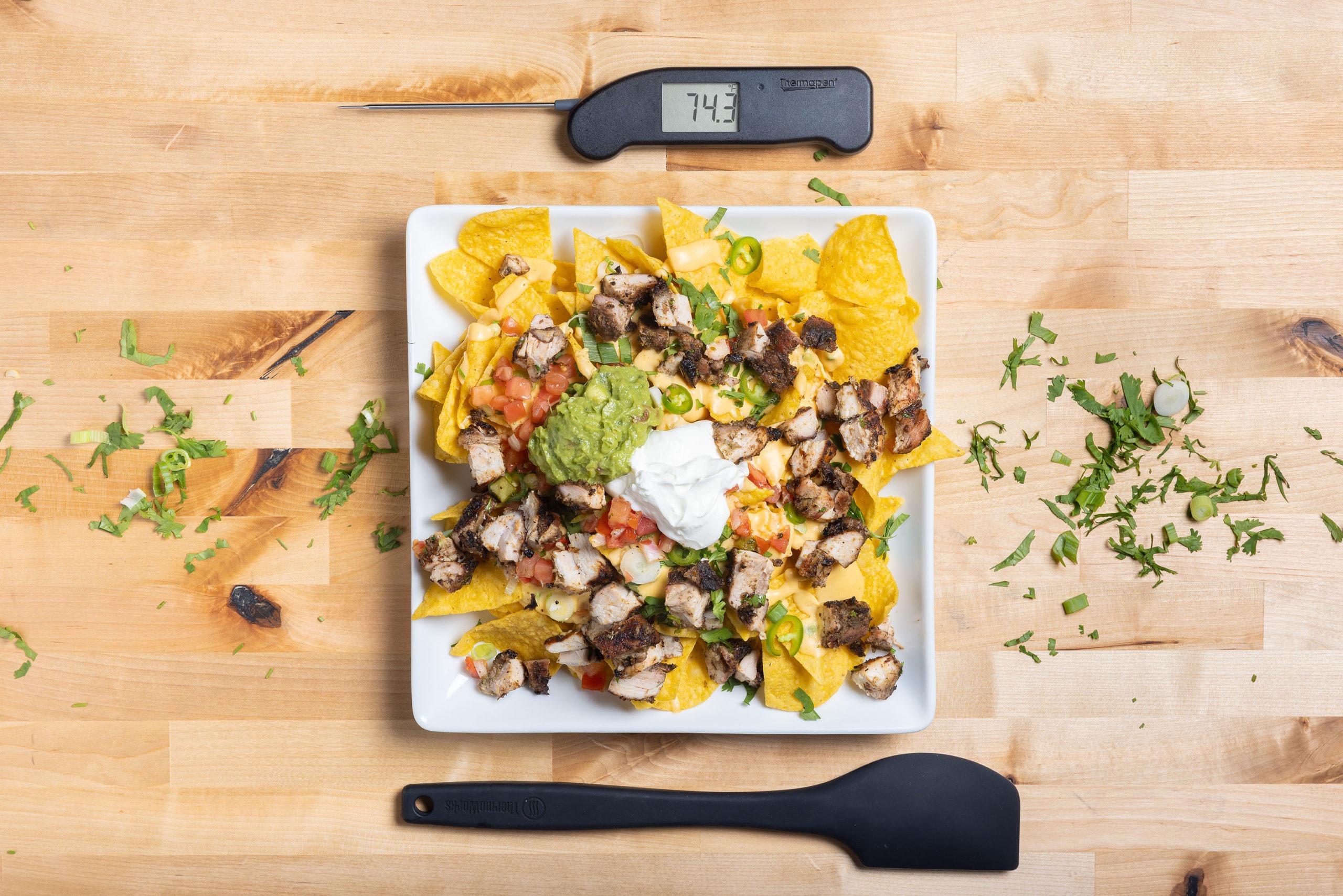 A plate of jerk chicken nachos with Thermapen and spatula