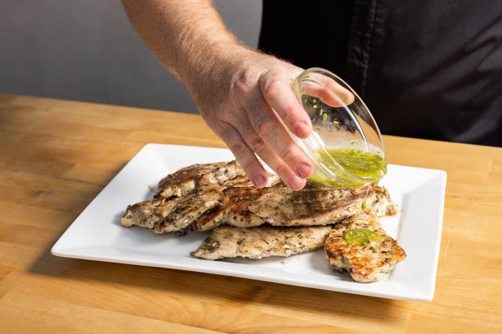 Dressing the grilled breasts with lemon sauce