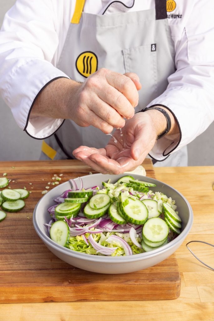 Squeezing lemon into topping salad