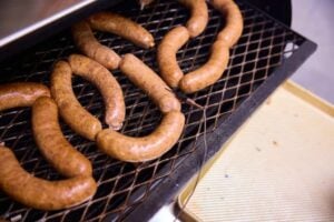 Sausages on the smoker with needle probe inserted