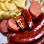 Hot link sausage on a plate with sides
