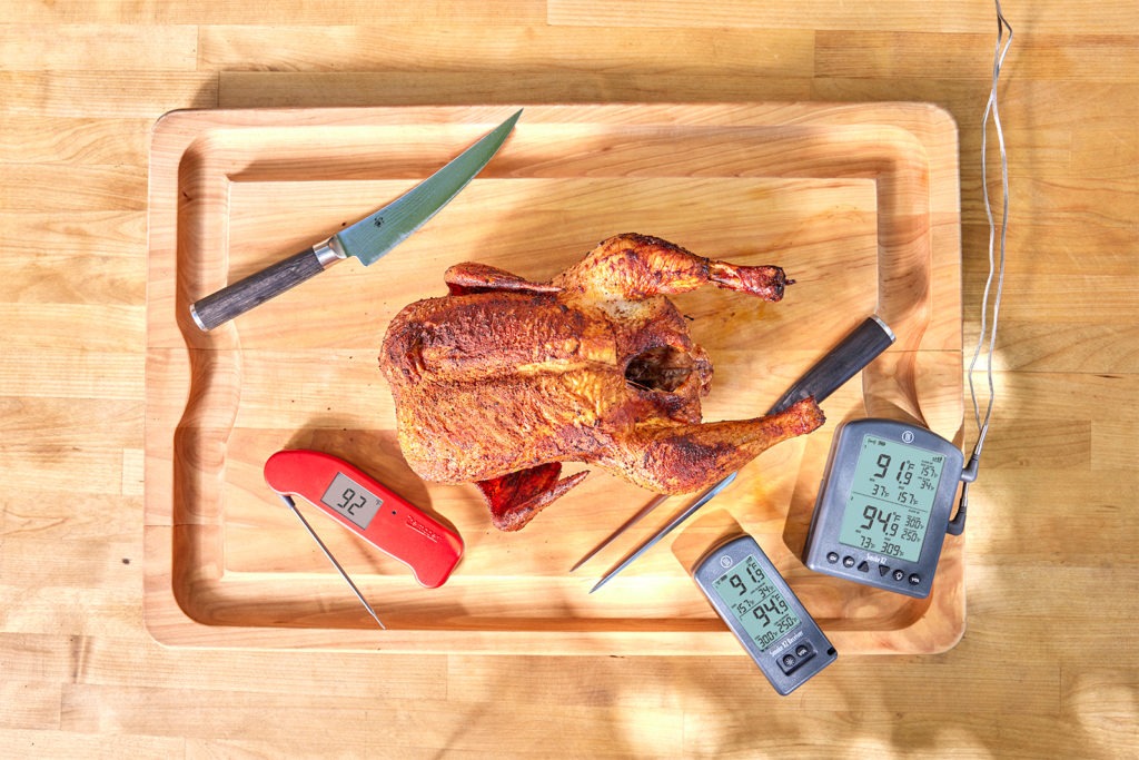Smoked chicken on cutting board with thermometers