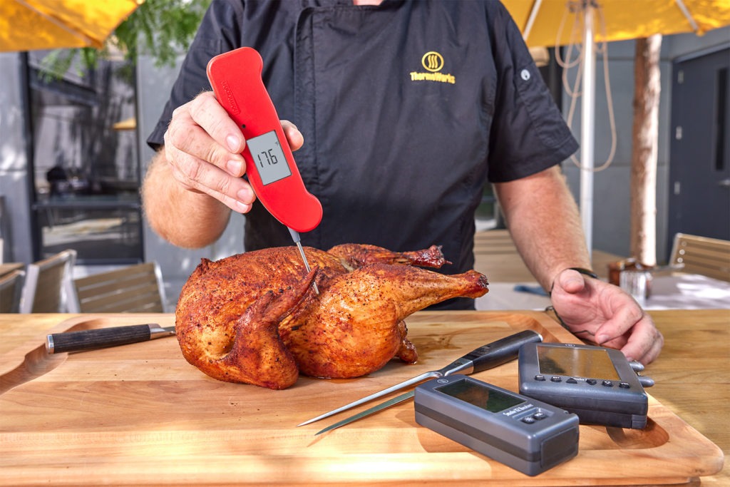 temping a chicken on a cutting board