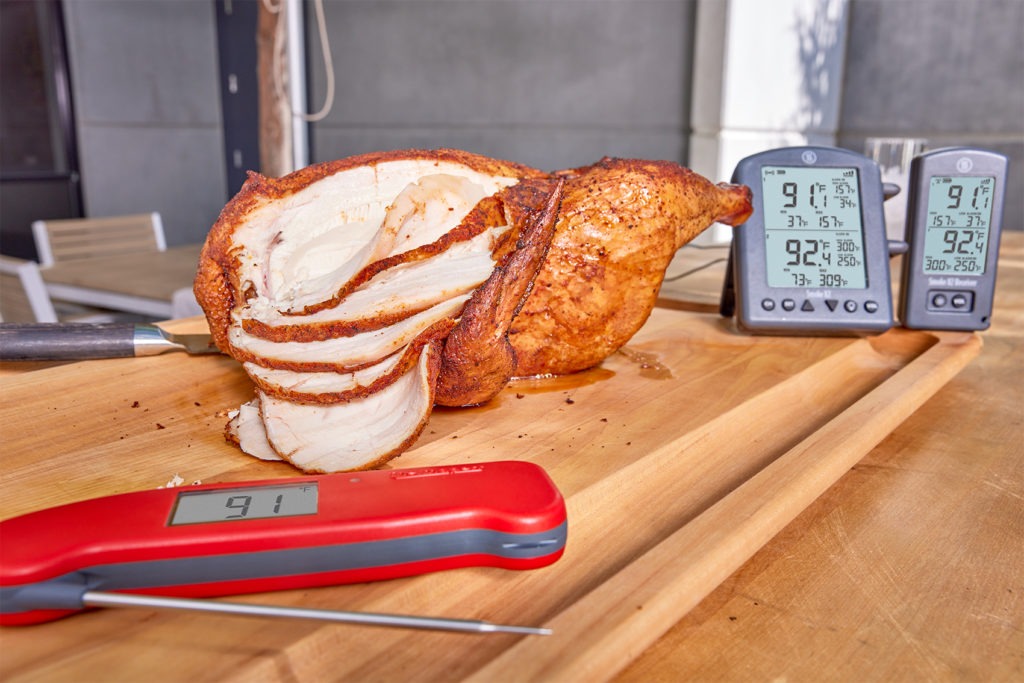 Chicken on a cutting board with thermometers