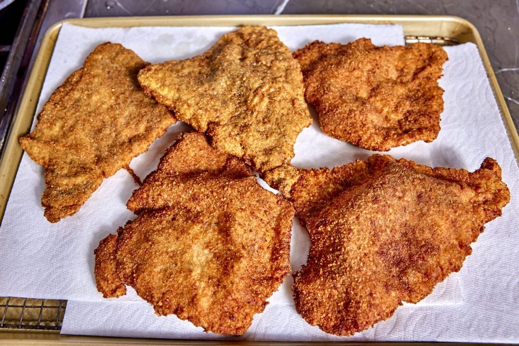 schnitzels on a pan drianing