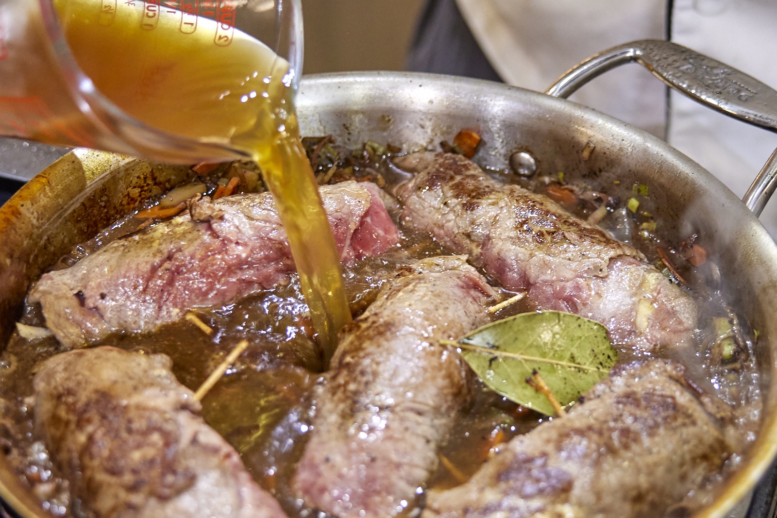 pouring stock into the rouladen pan