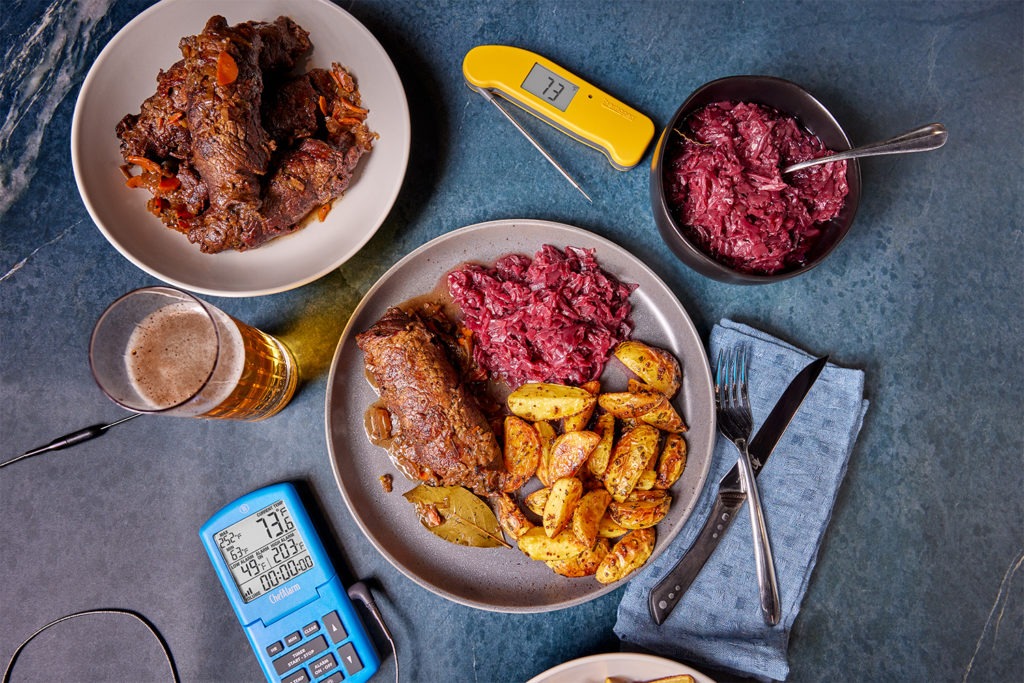 A meal of beef rouladen with potatoes, red cabbage, and thermometers