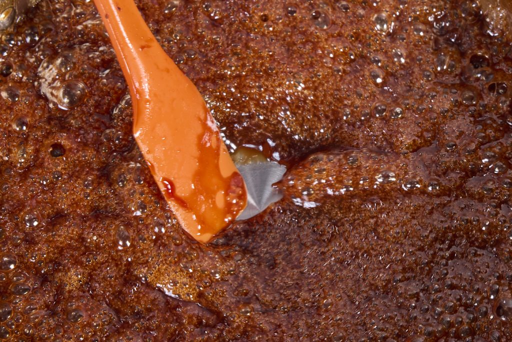 the thickened sauce showing pan as a spatula is dragged through