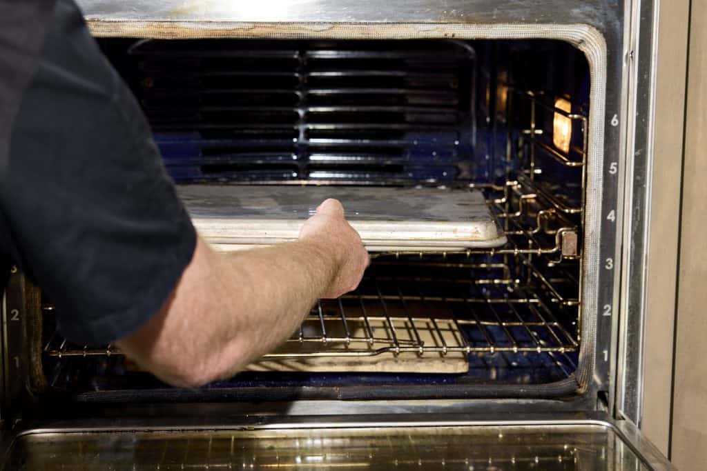 Putting the buns in the oven with the pan atop