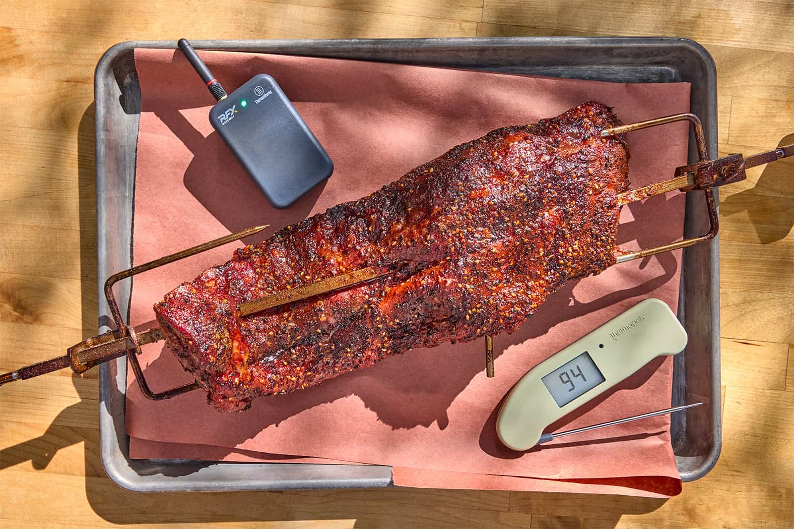 Rotisserie cooked ribs with thermometers on tray