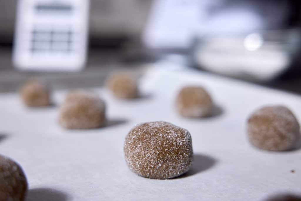 A cookie ball on a sheet with timer in the background