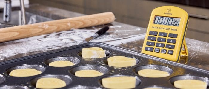 rolls in the pan ready to proof, timer in background