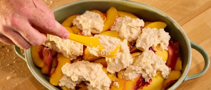 Dolloping the dough onto the cobbler